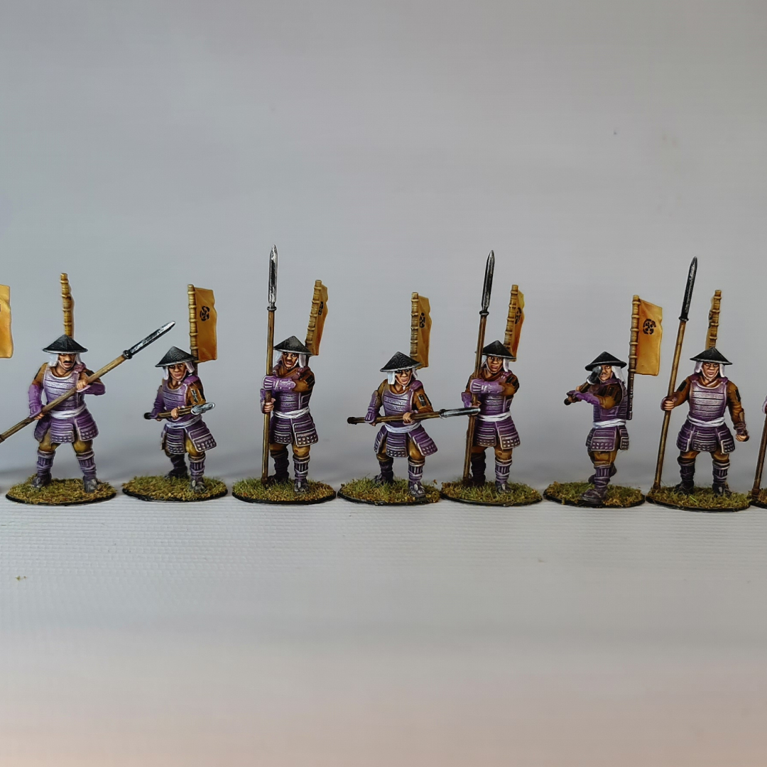 A composition image of 3D printable Ashigaru Yari Spearman miniatures. The upper part shows unpainted grey 3D renders, while the lower part displays fully painted examples in purple and brown armor, holding long spears (yari) and wearing conical hats (jingasa).