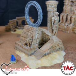 Painted 3D print of an ancient Egyptian ruin with a celestial star portal ring, hieroglyphs, and a statue of the god Horus, set on a desert wargaming mat.