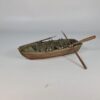 Painted 3D printed model of a classic wooden rowboat for tabletop wargaming, featuring detailed wood grain, benches, oars, and oarlocks on a white background.