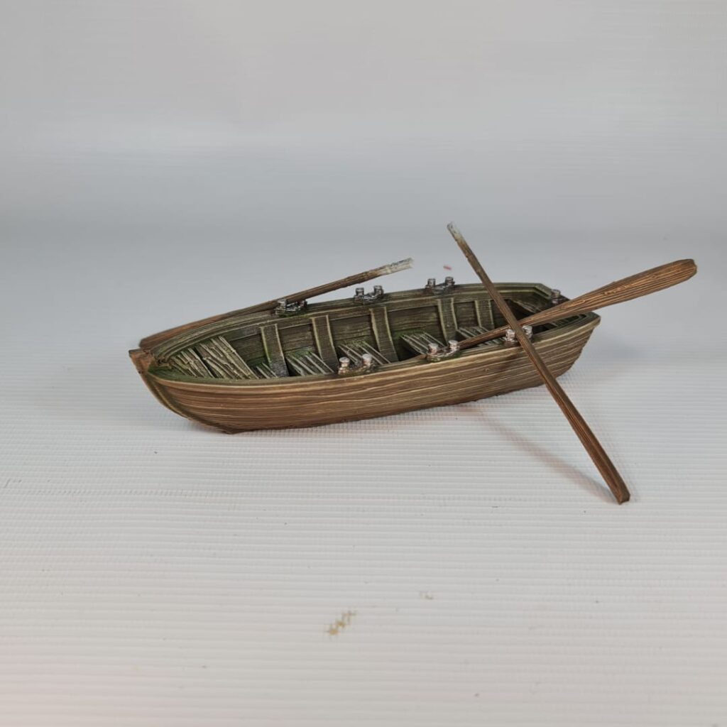Painted 3D printed model of a classic wooden rowboat for tabletop wargaming, featuring detailed wood grain, benches, oars, and oarlocks on a white background.