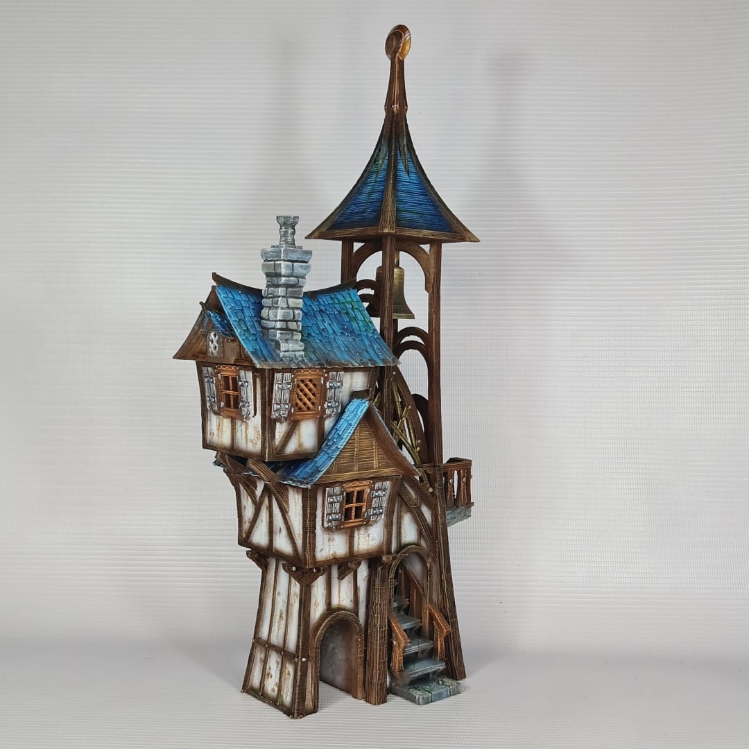3D printed and painted model of Parson's Lodge, a tall medieval fantasy bell tower with half-timbered walls, blue shingled roofs, stone chimney, and wooden stairs.