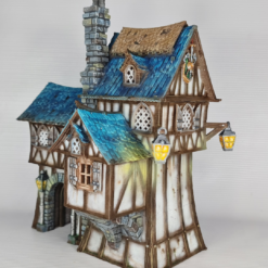 3D printed and painted model of the Oldkeep Barracks, a medieval half-timbered building with blue shingled roofs, hanging lanterns, and wooden textures for tabletop gaming.