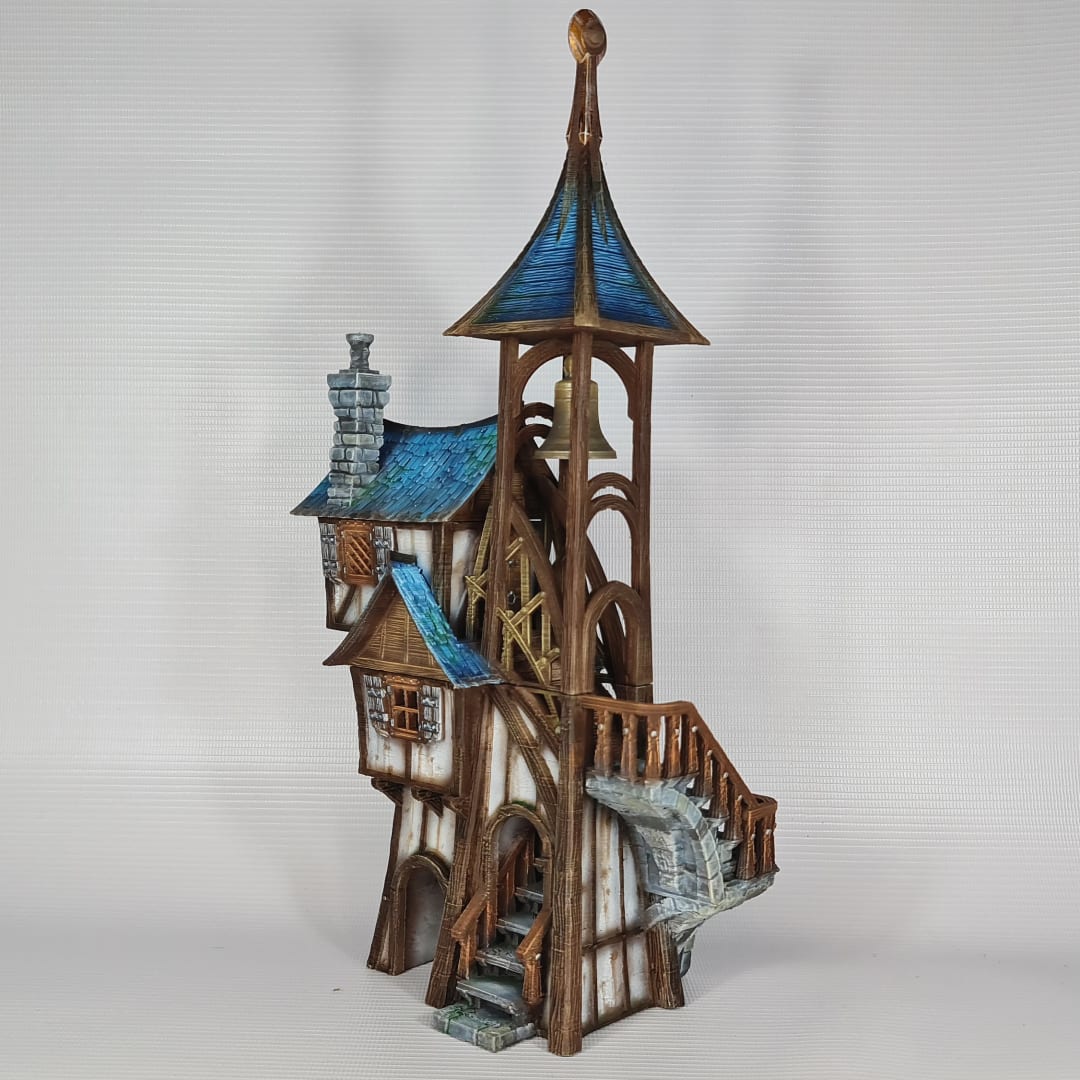 3D printed and painted model of Parson's Lodge, a tall medieval fantasy bell tower with half-timbered walls, blue shingled roofs, stone chimney, and wooden stairs.